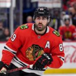 Speculative image projection of Alex Tuch in a Chicago Blackhawks red home jersey, an ideal NHL free agent target and potential new linemate for Connor Bedard.