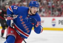 Alexander Nikishin wearing a New York Rangers home jersey and helmet in trade rumor image after being linked to New York from the Carolina Hurricanes