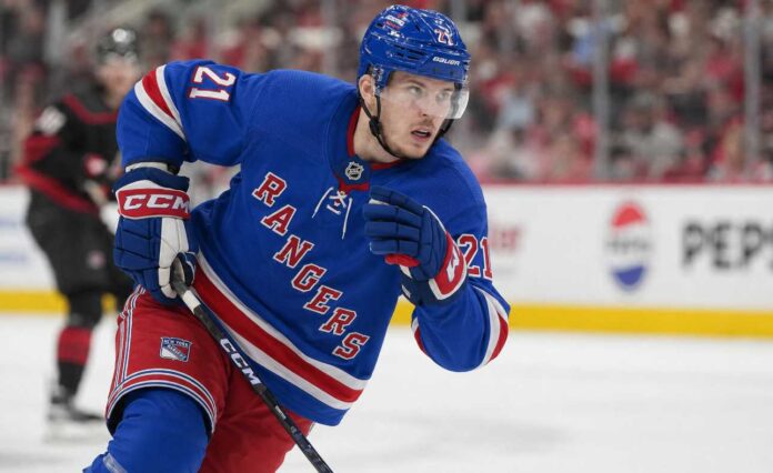 Alexander Nikishin wearing a New York Rangers home jersey and helmet in trade rumor image after being linked to New York from the Carolina Hurricanes