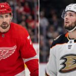 Anaheim Ducks Linked to Detroit Red Wings Captain Dylan Larkin in Blockbuster Rumor Split image featuring Detroit Red Wings captain Dylan Larkin in a red jersey and Anaheim Ducks young center Mason McTavish in a white jersey, illustrating the rumored NHL trade scenario.