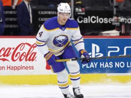 Bowen Byram Trade Rumors: 3 Teams Targeting the Sabres Star Buffalo Sabres defenseman Bowen Byram #4 skating with the puck on ice in a white away jersey, a top target in NHL trade rumors for teams like the Philadelphia Flyers and Chicago Blackhawks.