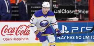 Bowen Byram Trade Rumors: 3 Teams Targeting the Sabres Star Buffalo Sabres defenseman Bowen Byram #4 skating with the puck on ice in a white away jersey, a top target in NHL trade rumors for teams like the Philadelphia Flyers and Chicago Blackhawks.