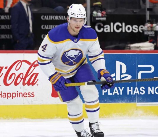 Bowen Byram Trade Rumors: 3 Teams Targeting the Sabres Star Buffalo Sabres defenseman Bowen Byram #4 skating with the puck on ice in a white away jersey, a top target in NHL trade rumors for teams like the Philadelphia Flyers and Chicago Blackhawks.