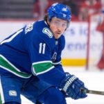 High-quality visualization of Brendan Gallagher wearing a Vancouver Canucks blue and green uniform on the ice, illustrating a rumored NHL trade from the Montreal Canadiens.