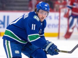 Brendan Gallagher Trade Rumors: Vancouver Canucks & Montreal Canadiens High-quality visualization of Brendan Gallagher wearing a Vancouver Canucks blue and green uniform on the ice, illustrating a rumored NHL trade from the Montreal Canadiens.