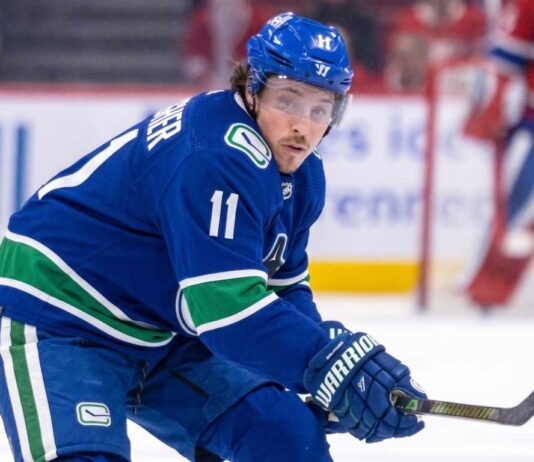 High-quality visualization of Brendan Gallagher wearing a Vancouver Canucks blue and green uniform on the ice, illustrating a rumored NHL trade from the Montreal Canadiens.