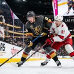 How to Watch Carolina Hurricanes vs Vegas Golden Knights Game 4 | TV & Prediction Stanley Cup Final Game 4 action: Mitch Marner (grey jersey, #16) of the Vegas Golden Knights and Jackson Blake (white jersey, #51) of the Carolina Hurricanes battle on the ice at T-Mobile Arena.
