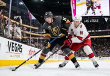 How to Watch Carolina Hurricanes vs Vegas Golden Knights Game 4 | TV & Prediction Stanley Cup Final Game 4 action: Mitch Marner (grey jersey, #16) of the Vegas Golden Knights and Jackson Blake (white jersey, #51) of the Carolina Hurricanes battle on the ice at T-Mobile Arena.
