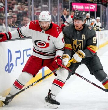 Carolina Hurricanes and Vegas Golden Knights puck battle featuring captains Jordan Staal (#11, 'C') and Jack Eichel (#9, 'A') along the boards during Game 6 of the 2026 Stanley Cup Final.