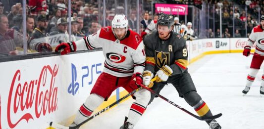 Carolina Hurricanes and Vegas Golden Knights puck battle featuring captains Jordan Staal (#11, 'C') and Jack Eichel (#9, 'A') along the boards during Game 6 of the 2026 Stanley Cup Final.