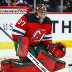 Will the New Jersey Devils Trade for Winnipeg Jets Goalie Connor Hellebuyck? Connor Hellebuyck (No. 37) wearing a custom New Jersey Devils home jersey, mask, and goaltending pads, posed in a butterfly save position during an NHL hockey game, a visualization of potential trade rumors.