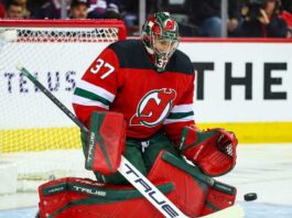 Connor Hellebuyck (No. 37) wearing a custom New Jersey Devils home jersey, mask, and goaltending pads, posed in a butterfly save position during an NHL hockey game, a visualization of potential trade rumors.