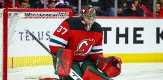 Will the New Jersey Devils Trade for Winnipeg Jets Goalie Connor Hellebuyck? Connor Hellebuyck (No. 37) wearing a custom New Jersey Devils home jersey, mask, and goaltending pads, posed in a butterfly save position during an NHL hockey game, a visualization of potential trade rumors.