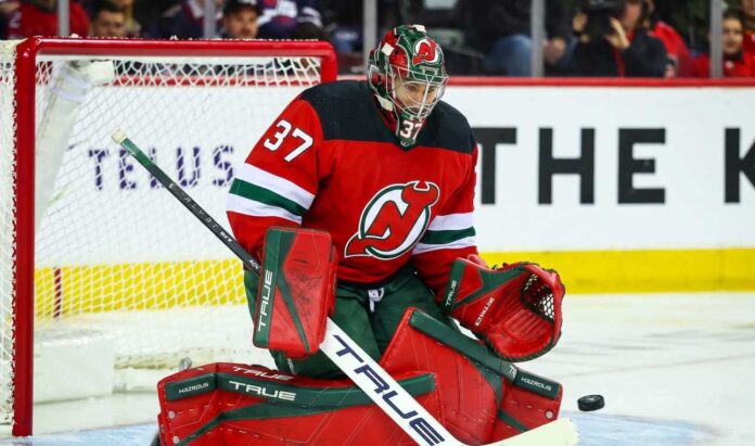 connor-hellebuyck-winnipeg-jets-trade-devils Connor Hellebuyck (No. 37) wearing a custom New Jersey Devils home jersey, mask, and goaltending pads, posed in a butterfly save position during an NHL hockey game, a visualization of potential trade rumors.