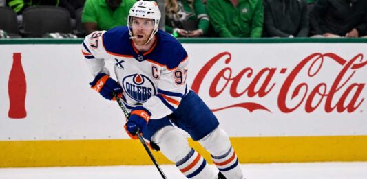 Connor McDavid skating for the Edmonton Oilers with a Coca-Cola board ad in a 2026-27 fantasy hockey point projections preview