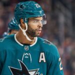 Darnell Nurse wearing a San Jose Sharks jersey and helmet amid Edmonton Oilers trade rumors linking him to San Jose