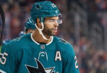 Darnell Nurse wearing a San Jose Sharks jersey and helmet amid Edmonton Oilers trade rumors linking him to San Jose