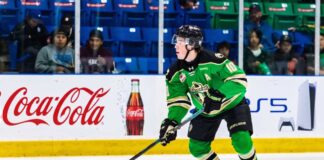 Daxon Rudolph, 2026 NHL Draft prospect, skating with the puck in a Prince Albert Raiders green jersey (number 10) during a WHL game, showcasing junior hockey stats for Florida Panthers scouts.