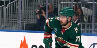 A digitally altered image showing Dylan Larkin wearing a green Minnesota Wild home jersey and helmet, reflecting ongoing NHL trade rumors.