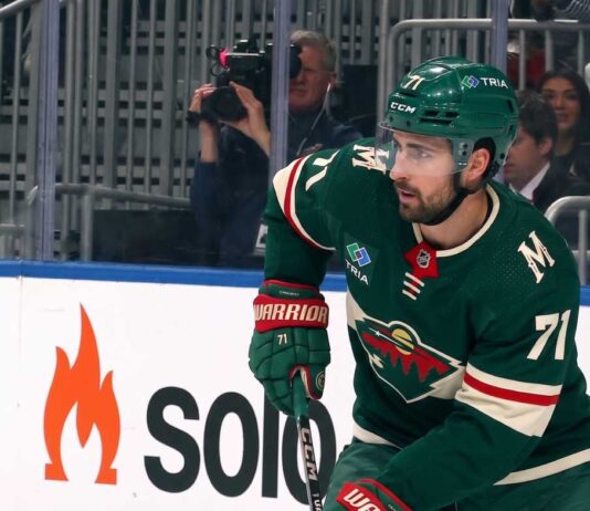 A digitally altered image showing Dylan Larkin wearing a green Minnesota Wild home jersey and helmet, reflecting ongoing NHL trade rumors.