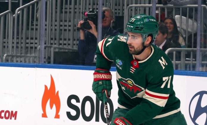A digitally altered image showing Dylan Larkin wearing a green Minnesota Wild home jersey and helmet, reflecting ongoing NHL trade rumors.