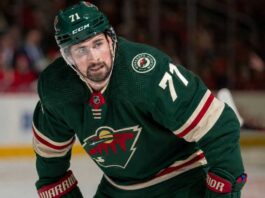 Dylan Larkin Trade Rumors: Is He Going to the Minnesota Wild? Photorealistic composite image showing NHL center Dylan Larkin in a Minnesota Wild home jersey with number 71 and a captain’s “C”, visualizing trade rumors linking him to Minnesota.
