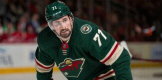 Dylan Larkin Trade Rumors: Is He Going to the Minnesota Wild? Photorealistic composite image showing NHL center Dylan Larkin in a Minnesota Wild home jersey with number 71 and a captain’s “C”, visualizing trade rumors linking him to Minnesota.