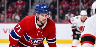 Dylan Larkin Trade Rumors: Will the Montreal Canadiens Strike a Deal? Montreal Canadiens forward Dylan Larkin (number 71) is captured in a red home jersey, skating with the puck in a high-quality NHL action photograph. The photo highlights his focus and skill, a key figure in recent trade speculation.