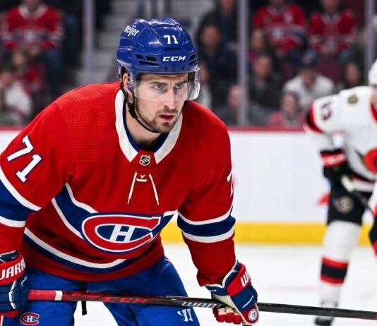 Dylan Larkin Trade Rumors: Will the Montreal Canadiens Strike a Deal? Montreal Canadiens forward Dylan Larkin (number 71) is captured in a red home jersey, skating with the puck in a high-quality NHL action photograph. The photo highlights his focus and skill, a key figure in recent trade speculation.