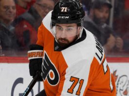 Dylan Larkin Trade Rumors: Will the Detroit Red Wings Deal With the Philadelphia Flyers? Detroit Red Wings captain Dylan Larkin wearing a Philadelphia Flyers home uniform and orange helmet in a hockey pose, illustrating recent NHL trade rumors linking him to Philly.