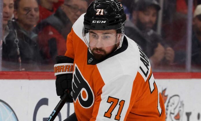 dylan-larkin-philadelphia-flyers-trade-rumor Detroit Red Wings captain Dylan Larkin wearing a Philadelphia Flyers home uniform and orange helmet in a hockey pose, illustrating recent NHL trade rumors linking him to Philly.