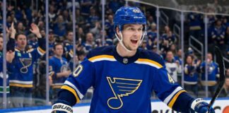 Smiling Elias Pettersson wearing a St. Louis Blues home jersey with Blue Note logo and #40 helmet, celebrating on ice with cheering crowd; speculative trade visualization.