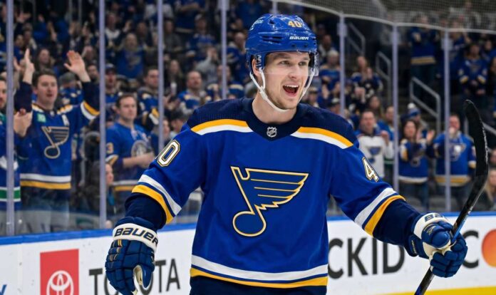 elias-pettersson-canucks-blues-trade-rumor Smiling Elias Pettersson wearing a St. Louis Blues home jersey with Blue Note logo and #40 helmet, celebrating on ice with cheering crowd; speculative trade visualization.