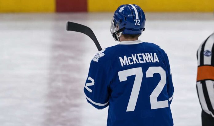 gavin-mckenna-toronto-maple-leafs-2026-draft Gavin McKenna wearing a blue Toronto Maple Leafs home jersey with number 72 and the numbered blue helmet, seen from behind on an ice rink, viewed as the projected #1 overall pick for the 2026 NHL Draft.
