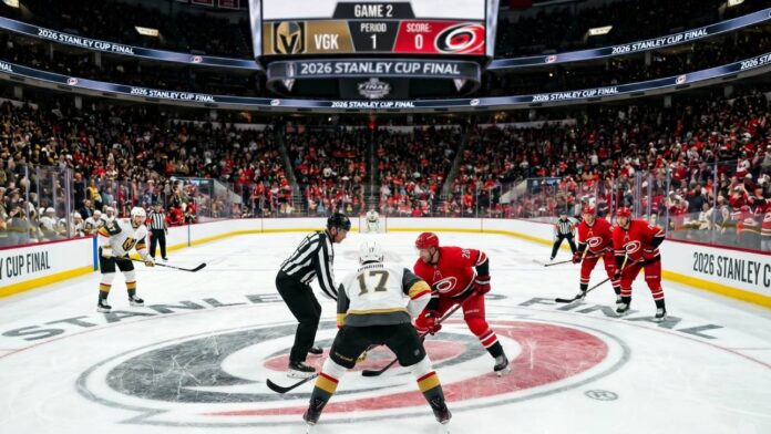 Vegas Golden Knights and Carolina Hurricanes center ice faceoff during Period 1 of the 2026 Stanley Cup Final Game 2, showing a packed arena and scoreboard.