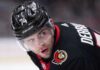 Jake DeBrusk Trade Rumors: Ottawa Senators & Vancouver Canucks Linked A close-up view visualizing Jake DeBrusk in a black Ottawa Senators hockey jersey and black helmet with the number 74.