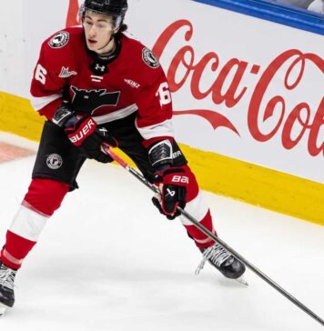 Maddox Dagenais #16 of the Quebec Remparts QMJHL, a 6'4" center, skating with the puck. Background rink boards with large Coca-Cola logo. Image from an article on Utah Mammoth NHL Draft pick analysis.