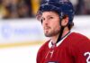 Montreal Canadiens Trade Rumors: Anaheim Ducks Mason McTavish A detailed close-up view of NHL player Mason McTavish wearing a red Montreal Canadiens (Habs) home jersey with the number 23 on the shoulder and a blue Bauer helmet with the 'CH' logo, standing on an ice rink.