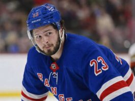 Mason McTavish wearing a New York Rangers home jersey amid trade rumors involving the Anaheim Ducks