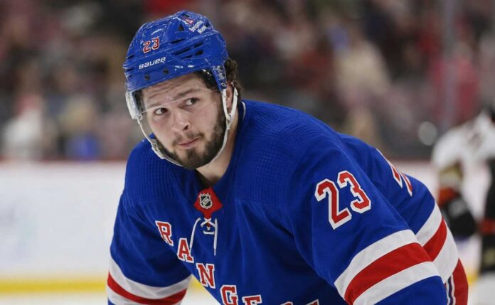 Mason McTavish wearing a New York Rangers home jersey amid trade rumors involving the Anaheim Ducks