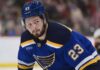 Mason McTavish wearing a St. Louis Blues home jersey amid trade rumors involving the Anaheim Ducks.