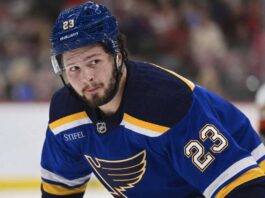 Mason McTavish wearing a St. Louis Blues home jersey amid trade rumors involving the Anaheim Ducks.