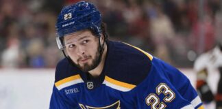 Mason McTavish wearing a St. Louis Blues home jersey amid trade rumors involving the Anaheim Ducks.