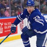 Matthew Knies #23 of the Toronto Maple Leafs skating during an NHL game, surrounded by NHL trade rumors.