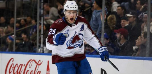 Nathan MacKinnon Point Projections 2026-27: Goals, Assists and Fantasy Outlook Nathan MacKinnon point projections 2026-27 fantasy hockey outlook with Colorado Avalanche star celebrating beside Coca-Cola and PS5 board ads