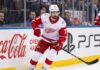 NHL News and NHL Scores: Larkin Trade Rumors & Stanley Cup Updates Detroit Red Wings captain Dylan Larkin skating in an away jersey during an NHL game, highlighting the latest NHL trade rumors and recent NHL news.