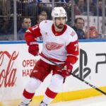 NHL News and NHL Scores: Larkin Trade Rumors & Stanley Cup Updates Detroit Red Wings captain Dylan Larkin skating in an away jersey during an NHL game, highlighting the latest NHL trade rumors and recent NHL news.