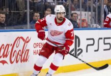 NHL News and NHL Scores: Larkin Trade Rumors & Stanley Cup Updates Detroit Red Wings captain Dylan Larkin skating in an away jersey during an NHL game, highlighting the latest NHL trade rumors and recent NHL news.