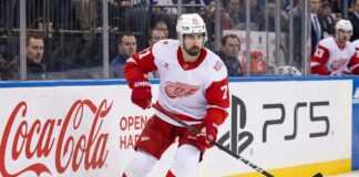 NHL News and NHL Scores: Larkin Trade Rumors & Stanley Cup Updates Detroit Red Wings captain Dylan Larkin skating in an away jersey during an NHL game, highlighting the latest NHL trade rumors and recent NHL news.