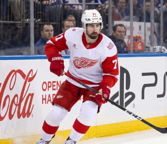 NHL News and NHL Scores: Larkin Trade Rumors & Stanley Cup Updates Detroit Red Wings captain Dylan Larkin skating in an away jersey during an NHL game, highlighting the latest NHL trade rumors and recent NHL news.